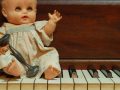 Gammel dukke på klaver
